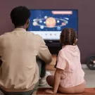 Father and daughter viewing television together.